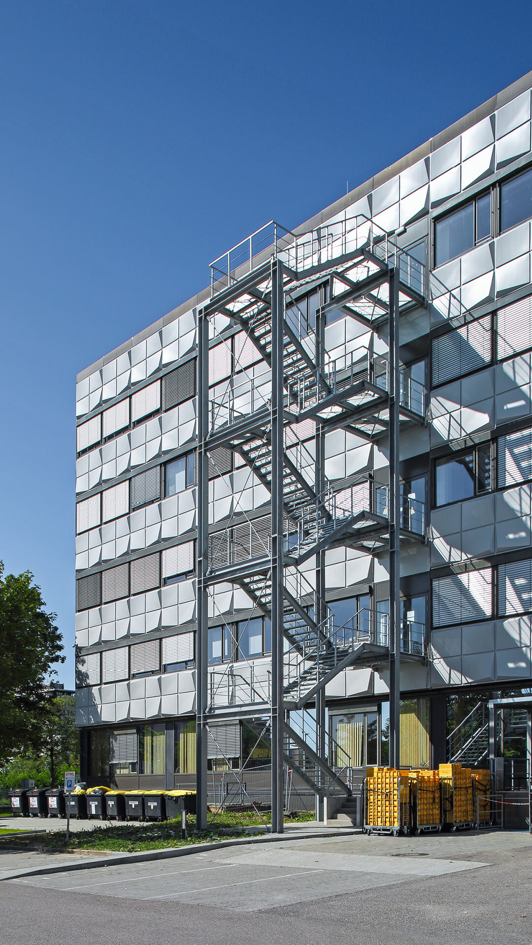 Montage einer Feuertreppe: Clevere Metallkonstruktion – stabiler Stahlunterbau, punktgenau auf tragenden Gebäudestützen angebracht.